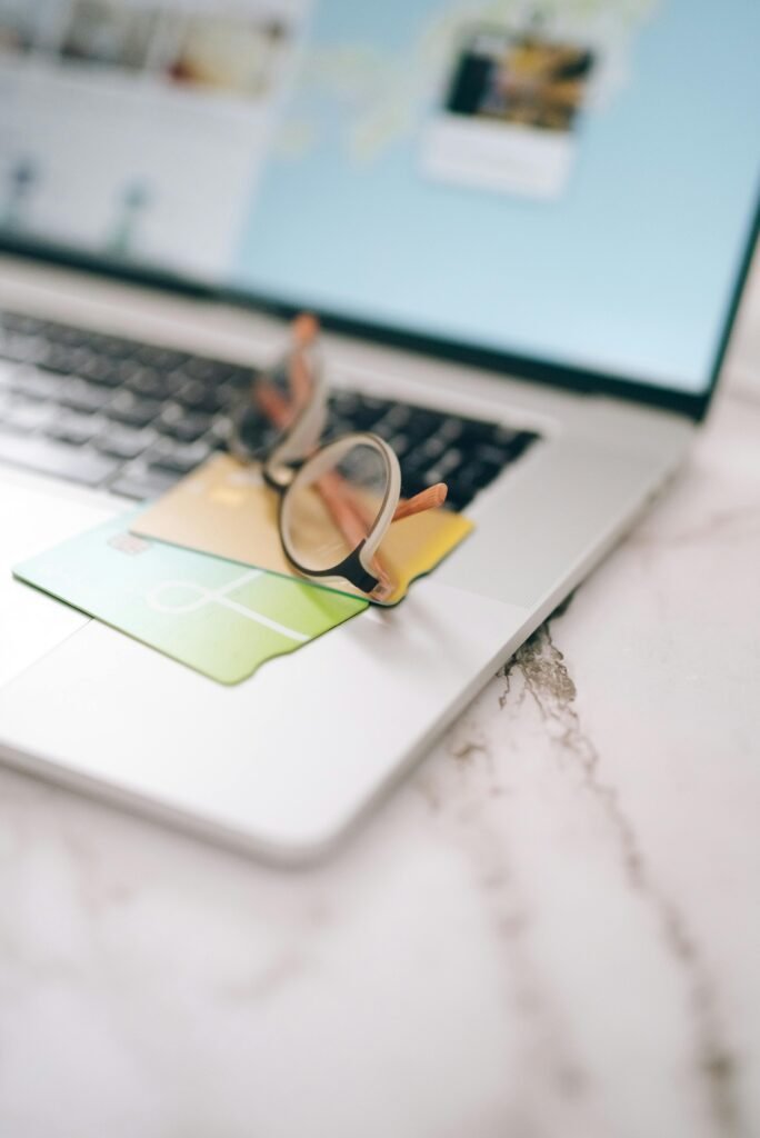 Eyeglasses and credit cards on a laptop representing online shopping and secure payments.