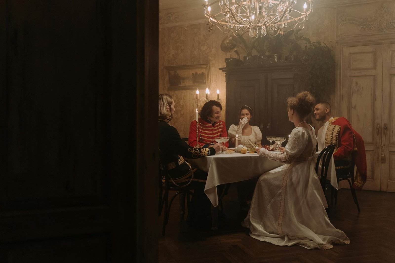 Elegant period costume dinner party with candlelight, evoking historic aristocracy.