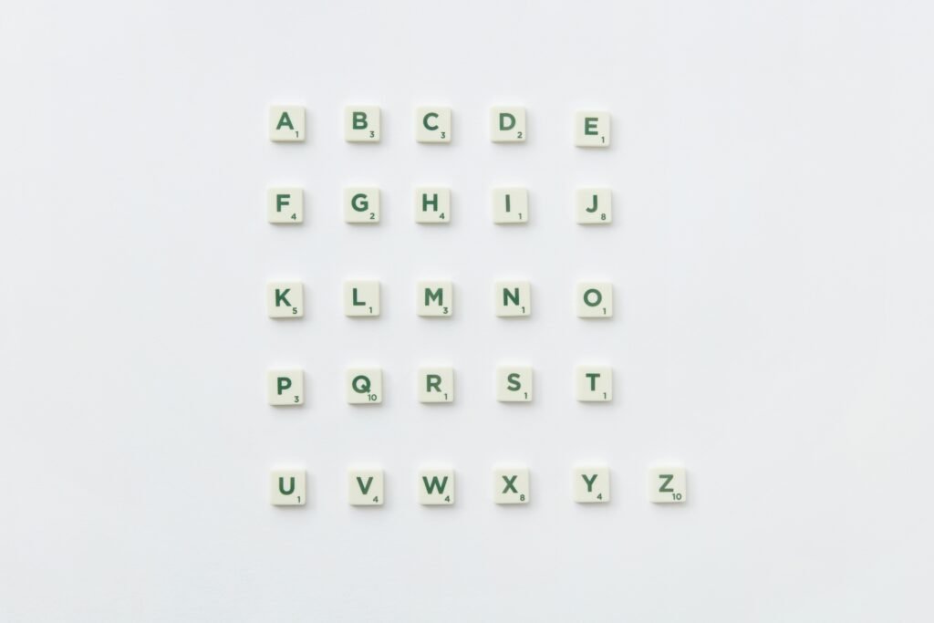 Scrabble letter tiles arranged into the alphabet on a white background.